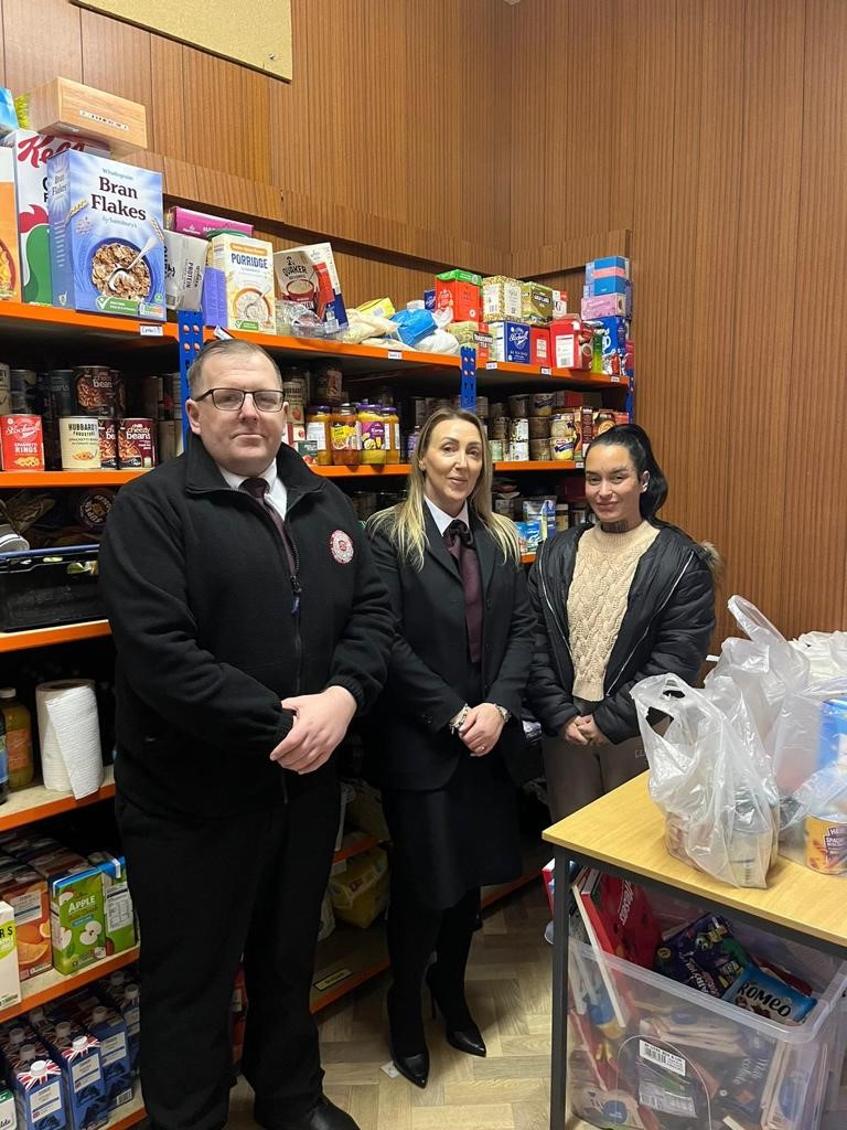 Staff stood in front of food collected for foodbank